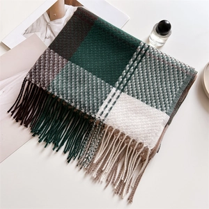 Dettaglio ravvicinato di una spessa sciarpa a quadri con frange morbide e motivo tartan