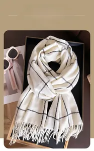 Close-up of winter scarf with black grid pattern, tassels and stylish accessories