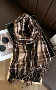Detailed view of coffee brown plaid scarf with tassels and soft cashmere-like texture