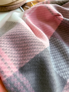 Dettaglio della sciarpa a quadri rosa e grigi con trama di tessitura diagonale
