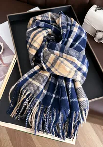 Close-up of classic navy and beige plaid scarf with soft tassels on a display tray