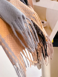 Dettaglio della texture in finto cashmere e delle frange sulla sciarpa a quadri