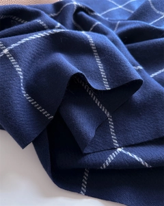 Detailed view of dark blue plaid scarf fabric showing soft weave texture and pattern
