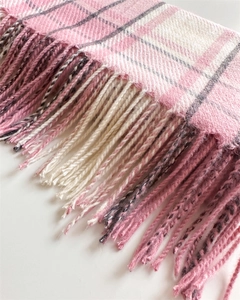 Detail shot of soft pink and grey checkered tassel scarf with thick wool texture