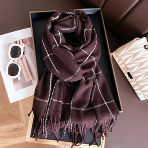 Detailed view of dark brown plaid scarf with fringe tassels in an elegant setting