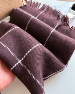 Detail shot of the deep reddish-brown plaid scarf with soft fringe and twill texture
