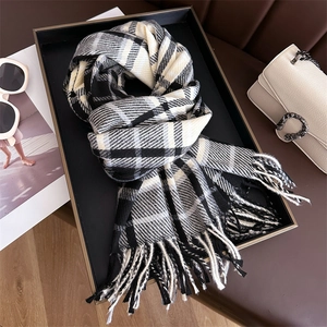 Close-up of black and beige checkered cashmere scarf with elegant fringe detail