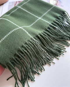 Detail of dark green cashmere-feel scarf with white grid pattern and fine fringe edges