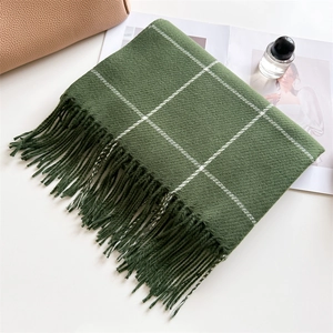 Deep green plaid faux cashmere scarf with long fringe displayed on a cozy beige background