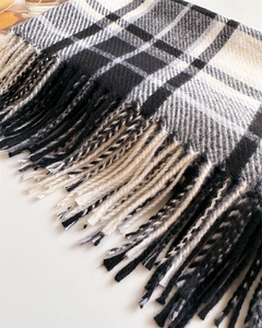 Close-up of thick checkered cashmere-feel scarf texture and hand-knotted fringe detail