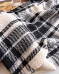 Close-up of black and white checkered scarf with soft twill weave and fringe details