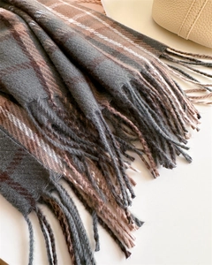 Close-up of classic plaid scarf showing thick twill weave texture and long fringe tassels