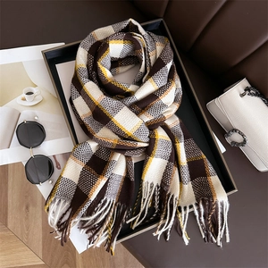Gros plan d'une écharpe à carreaux doux avec franges, motif à damier marron et jaune