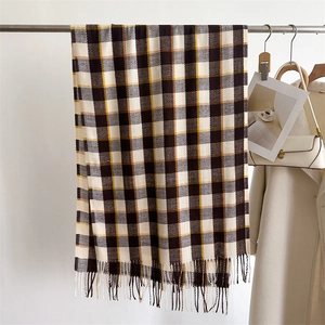 Détail d'une écharpe à carreaux marron avec franges, châle chaud style cachemire hiver