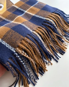 Gros plan sur l'écharpe à carreaux bleu marine et marron avec texture et longs franges