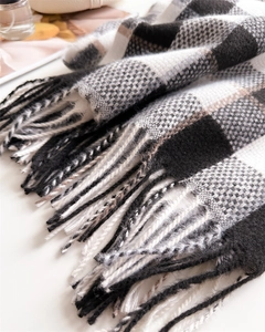 Détail d'une écharpe à carreaux noirs blancs et marron avec texture douce en cachemire