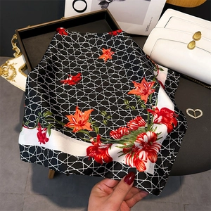 Detail of silk-like floral scarf with geometric grid pattern and red flower print