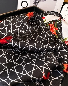 Detailed texture of silk scarf with floral lilies and geometric star patterns