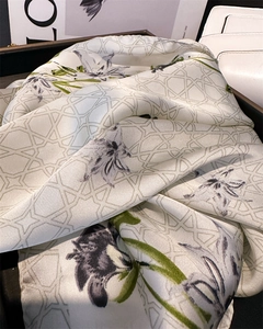 Detailed shot of lily print silk scarf with geometric patterns and hand-rolled edges