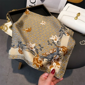 Detail of floral silk square scarf with lily print and elegant geometric patterns