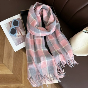 Détail d'une écharpe à carreaux rose et gris avec franges douces en décor lifestyle