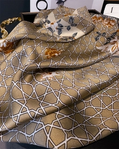 Close-up of floral silk square scarf with geometric star patterns and fine edge stitching