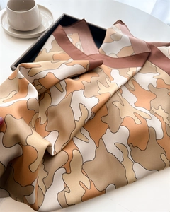 Detail of elegant cloud print silk scarf showing abstract beige and brown patterns