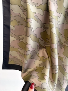 Detail showing the silky texture and earthy camouflage print of the square scarf