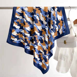 Close-up of leopard pattern silk scarf in blue and orange with dark blue borders