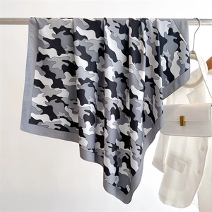 Detail of premium camouflage silk scarf with fine rolled edges draped elegantly on a hanger