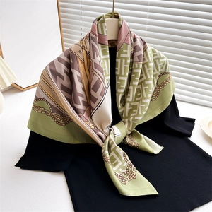 Detail of vintage French pattern silk scarf with double letter print and gold chain design