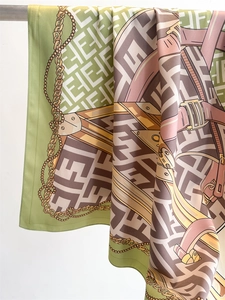 Detail of vintage silk scarf with chain pattern and geometric motifs hanging on a rod