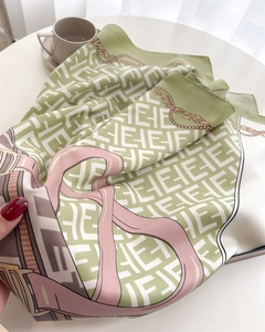 Detailed macro view of French silk scarf texture with chain prints and geometric motifs