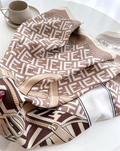 Detailed view of luxury silk scarf with golden chain pattern and classic F logo print