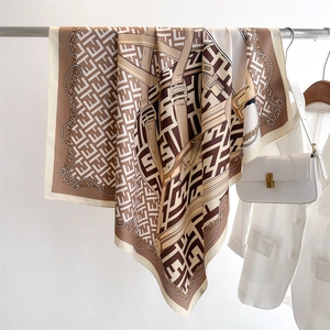 Close-up of French vintage silk scarf with chain print and FF pattern on a metal hanger