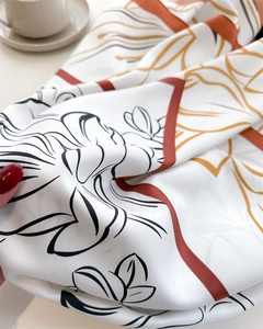 Detail of silk scarf with lotus pattern and terracotta lines on smooth satin fabric