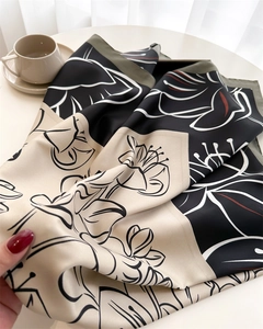 Detail view of large floral print on silky satin scarf featuring an elegant lotus pattern