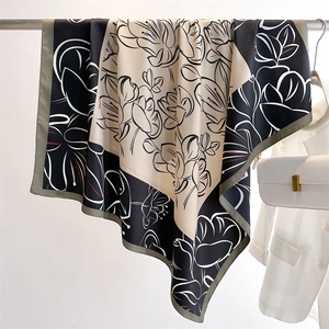 Detail of artistic floral pattern on vintage silk scarf draped on a metal hanger