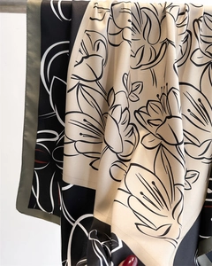 Detailed view of floral silk scarf featuring black line art flowers and block pattern