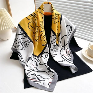 Elegant yellow and white floral silk scarf with 90cm satin square design on a black outfit