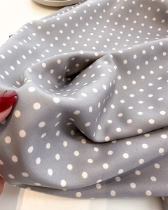 Detail of grey polka dot twill silk scarf showing soft fabric texture and elegant drape