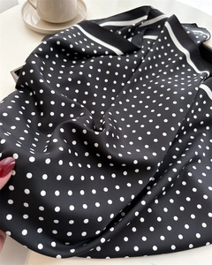 Close-up of silk satin polka dot scarf showing smooth texture and elegant drape