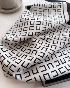 Detailopname van zijden sjaal met geometrisch patroon en elegante satijnen glans