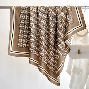 Dettaglio di un foulard in seta di lusso con motivo geometrico e bordo a righe