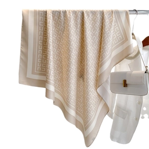 Elegante 90cm zijden sjaal in champagne met geometrisch patroon gedrapeerd over blazer