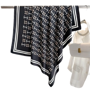 Elegante foulard in seta nera con motivi a stella bianchi e strisce su un supporto metallico