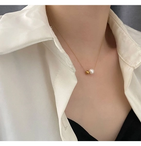Gros plan d'un collier chaîne dorée avec pendentifs en perles sur le cou d'un mannequin