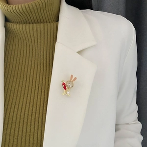 Cute golden rabbit brooch with crystals, red enamel carrot, and pearl on white blazer
