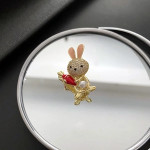 Cute bunny brooch with crystals and pearls on a mirror surface with reflection