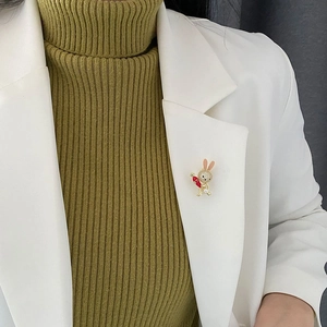 Cute bunny brooch in gold metal with sparkling crystals and pearl on a blazer